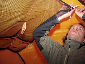 Kuivatusverkkojen ja lisäpyykkinarujen virittämistä telttaan.
