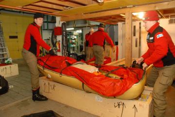 Unloading cargo boxes at Inns North traditional hall.