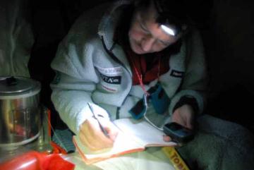 Office work in a warm tent. Henkku is calculation our distance traveled, with the aid of a GPS positioning device.